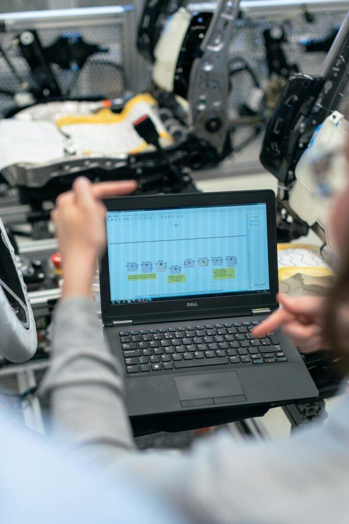 Effective Blog Promotion: Strategies to Increase Your Reach Engineers using a laptop to analyze software data in an industrial workshop setting.